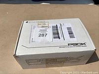 P90X branded mailer box with shipping labels and lot number sticker on the top, showing the exterior packaging of the workout set.