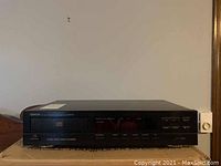 Full front view of the Denon CD player model DCD-460 showing black metal and plastic exterior with multiple control buttons and a digital display panel.