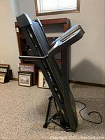 Folded Horizon CT81 treadmill leaning against wall, showing side profile and folded state