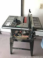 Front view of table saw on stand showing table surface, fence and miter gauge