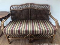 Front view of rattan love seat with striped cushion