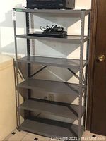 Front view of metal shelving unit with items on top shelf, showing overall structure.