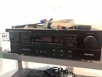 Front and angled view of Denon AVR-800 AV receiver showing the front panel with buttons, digital display, master volume knob, bundled A/V cables, and remote control on top.