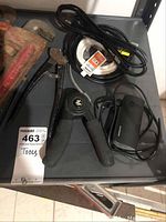 Two black-handled wire stripper, power cords, and other small electronics laid out on shelf