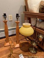 Wide view of all three lamps together showing two wooden lamps and one brass lamp with yellow shade