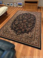 Full view of the oriental style rug on hardwood floor showing overall design and size.