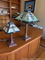 Both stained glass lamps on desk showing size difference and overall condition