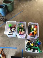 Four bins of assorted cleaning products including various spray bottles, cleaners, and other supplies.