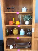Overall view of all vases, the faux plant, candle holders on top, and platters below on shelves
