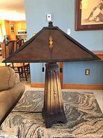 Full view of one table lamp showing heavy metal tapered base and large triangular tin-like shade.