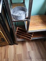 Wooden desk organizer showing carved compartments on wooden surface with metal frame