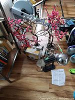 Overview of metal lamp, faux flower branches with lights, Lumie Body Clock box and instruction sheets on floor
