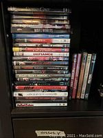 Shelf with various DVDs and Blu-Rays, showing titles such as Defiance, Narco, The Great King, Apocalypto, An Interview with God.