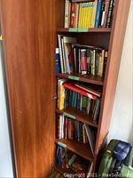 Wide view of wooden bookshelf filled with books and notebooks, showing general organization and quantity.