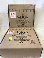 Two cardboard boxes labeled G40 Global LED String Lights with fragile handling stickers, stacked one open and one closed.