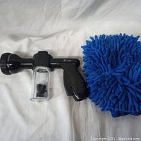 Foam gun and blue microfiber wash mitt shown side by side on white fabric background