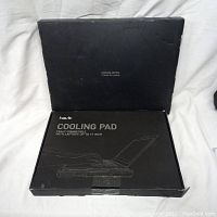 Photo of one Havit cooling pad in its original black box with gaming series branding and cooling pad image on box