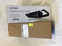 Two boxed portable vacuum cleaners, one branded KUTIME and one in an unmarked brown box