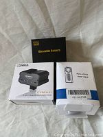 Three boxed items: Wearable Camera black box, Comica CVM-AX1 Audio Mixer box, Full HD DVR Camera box with label