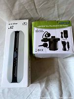 Two boxed air inflators, showing AGPTEK Two Way Electric Air Pump and Evolumen A2 Air Inflator packaging.