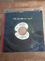 Single 'Revolution' by The Beatles on Apple Records in a black paper sleeve labeled 'The Beatles on Apple'.