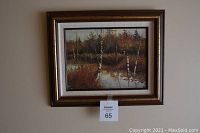 Full view of framed landscape painting with autumn birch trees and water.