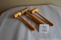 Three wooden leather crafting hammers displayed on a white surface with lot number card.