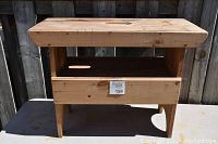 Front view of wooden cobbler's bench showing the main structure and drawer.