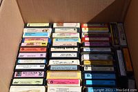 Top view showing neat rows of assorted 8 track tapes with titles and labels visible.