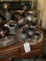 Overview of all silver tea set pieces on round tray and table