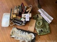 Overview shot showing lot items on wooden floor including the onyx base and pen tray with papers and various pens.