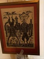 Framed black and white vintage cat print with rust colored matte border, showing two stylized dressed cats, one standing upright with cane and glasses, other upside down. Frame has wooden outer edges and appears worn and damaged at back.