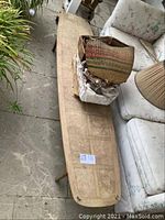 Overhead view of surfboard-shaped coffee table showing full length, surface wear, and tapered legs