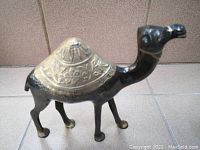 Photo of solid brass camel figurine showing detailed engraving on hump and body