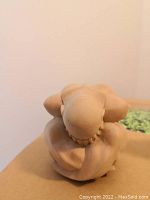 Top-down view of nude man sculpture showing head, shoulders and arm details