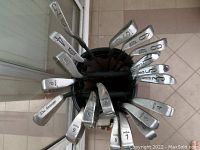 Top view showing club heads of multiple irons including Wilson and Lynx brands with visible numbering on each.