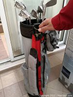 Golf clubs in bag with cover, showing overall lot and bag condition