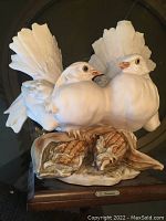 Front angle of handcrafted dove sculpture on wooden base with artist signature plaque visible.