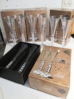 Four champagne flutes with spiral stems and etched Royal Caribbean logo, displayed with original boxes bearing Millennium cruise branding and year timeline.