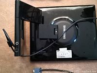 Back view of the Samsung flat screen monitor showing brand name, adjustable stand, and VGA connector cable.