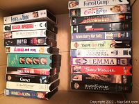 Photo of VHS movie cassettes stacked showing titles and condition