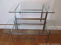 Photo showing the two tables stacked, highlighting glass tops and chrome bases, illustrating design and structure.