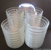 36 clear tempered glass prep/condiment bowls stacked in four piles, showing the stackable design and clear glass material.