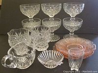 Lot of vintage glassware including six footed dessert cups with diamond pattern, a pink Jeanette Cherry Blossom plate, two matching saucers, two hexagon base pineapple/diamond cups, cut glass creamer, Heisey Ridgeleigh nut cup, and a Federal Glass star base shot glass
