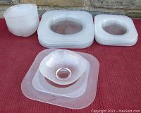 Full set laid out on red surface showing stacks of bowls, dinner plates, and salad plates