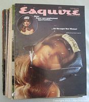 Front cover of one Esquire magazine featuring a woman with a helmet and a note clipped on it, text advertising employment opportunities for women.