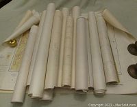 Rolled maps laid out with partial views, showing paper condition and rolled storage.