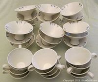 Set of 12 coffee cups stacked with 22 footed fruit compote bowls arranged in background showing design pattern and shapes