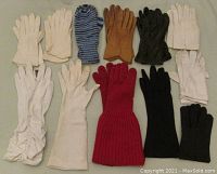 Twelve pairs of vintage women's gloves in assorted colors and materials laid flat to show style variety