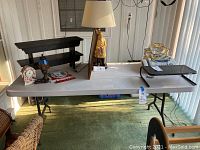 Full view of the banquet table with various items placed on top, showing overall size and legs.